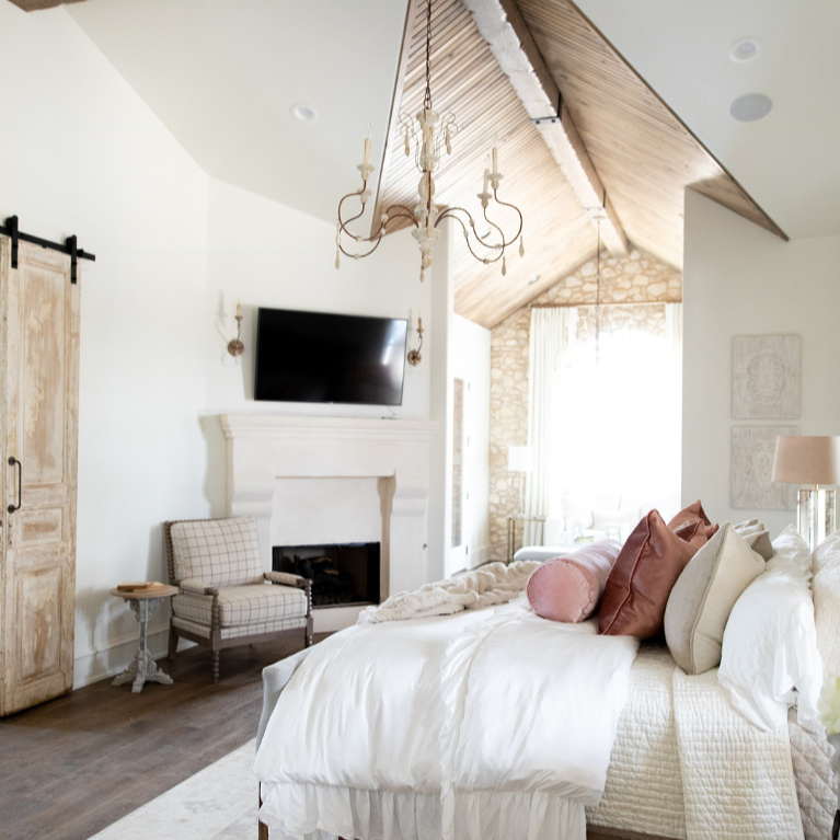 Rustic elegance in a French country bedroom with romantic decor by Brit Jones. #romanticbedrooms #interiordesign #frenchcountry #rusticdecor #barndoor #modernfrench