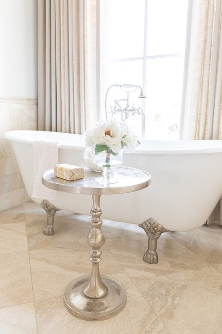 Romantic clawfoot tub in luxurious French country bathroom with travertine tile - Brit Jones. #frenchcountry #bathroomdecor #clawfoottub #romanticbathroom #interiordesign