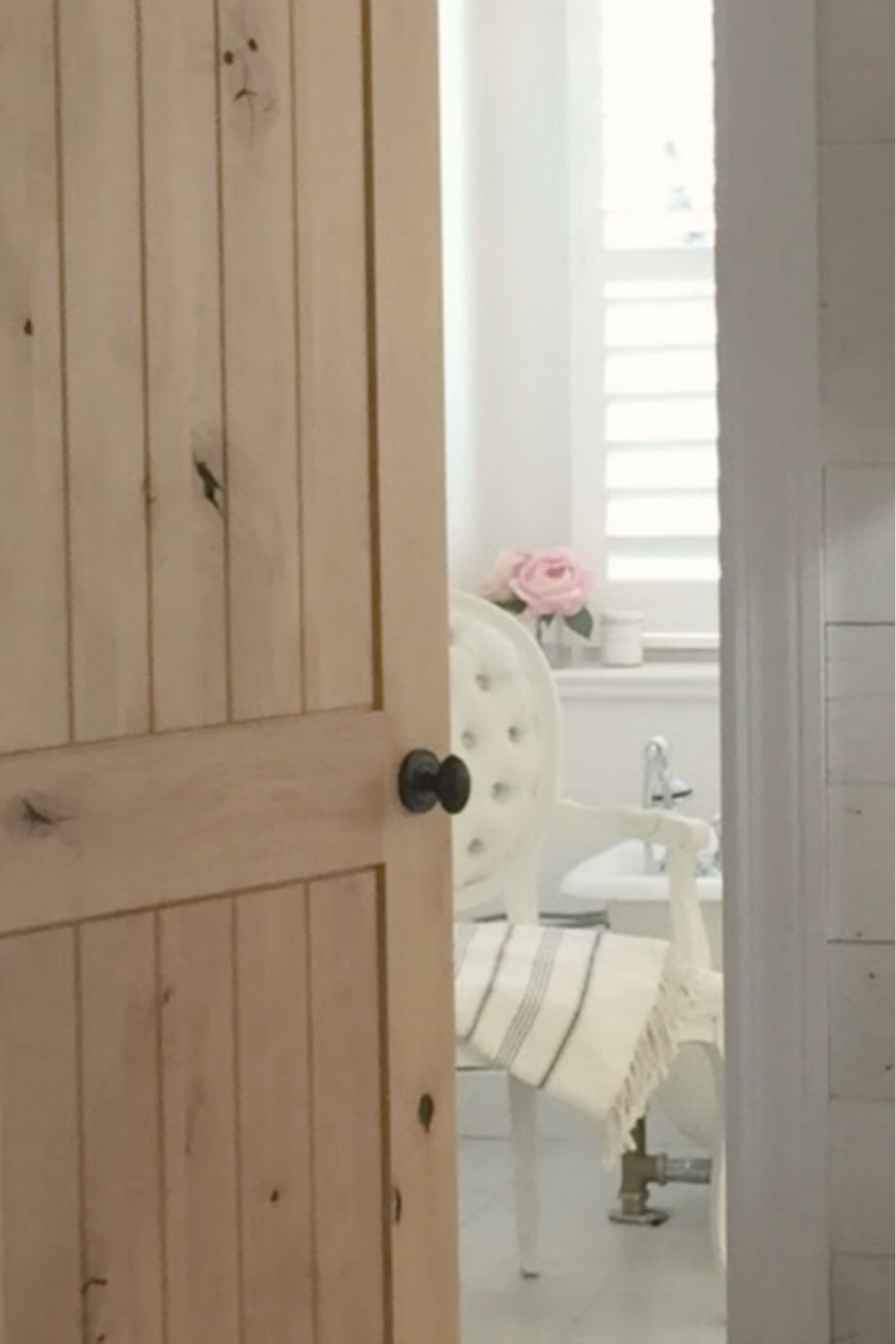 White Country French bathroom with knotty alder door - Hello Lovely Studio. #alderdoor #europeancountry #bathroomdesign