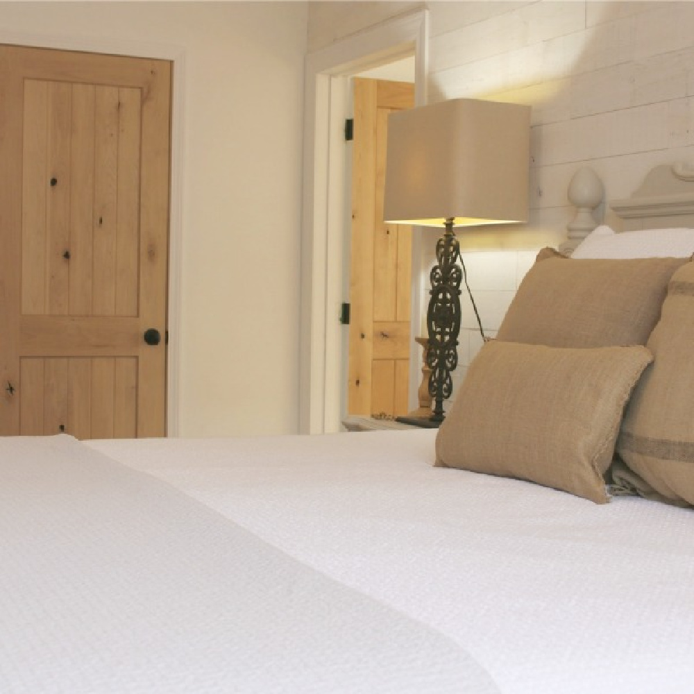 European country style bedroom with knotty alder interior doors and white bedding - Hello Lovely. #alderdoors