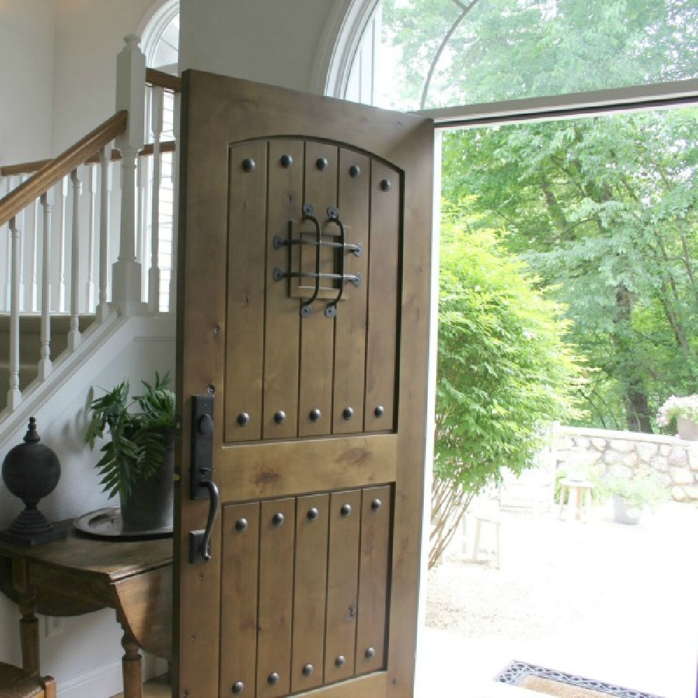 Rustic knotty alder exterior door with walnut stain and speakeasy in our European country cottage entry - Hello Lovely.