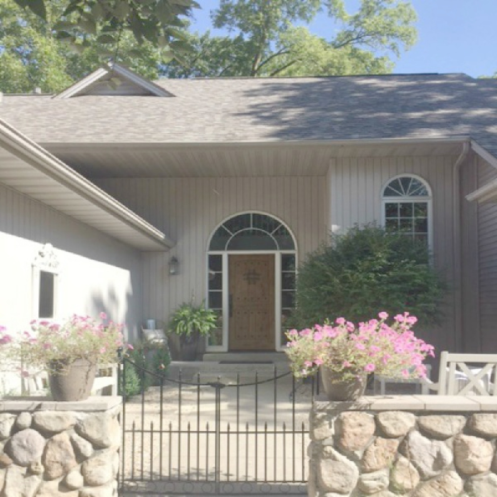 Hello Lovely Studio's home exterior with rustic stone walled entrance and knotty alder front door.