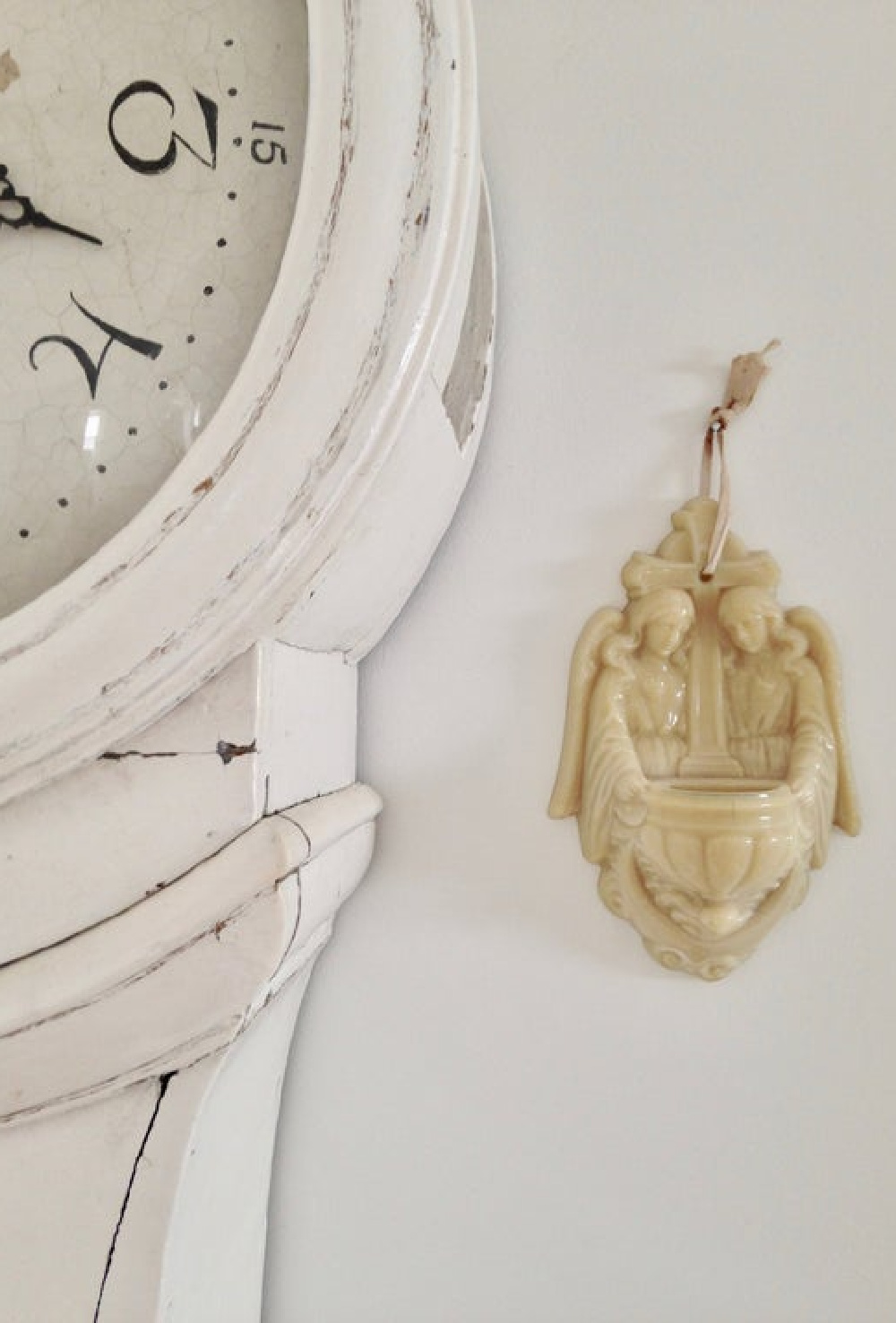 Antique French holy water font near white Swedish mora clock - My Petite Maison.