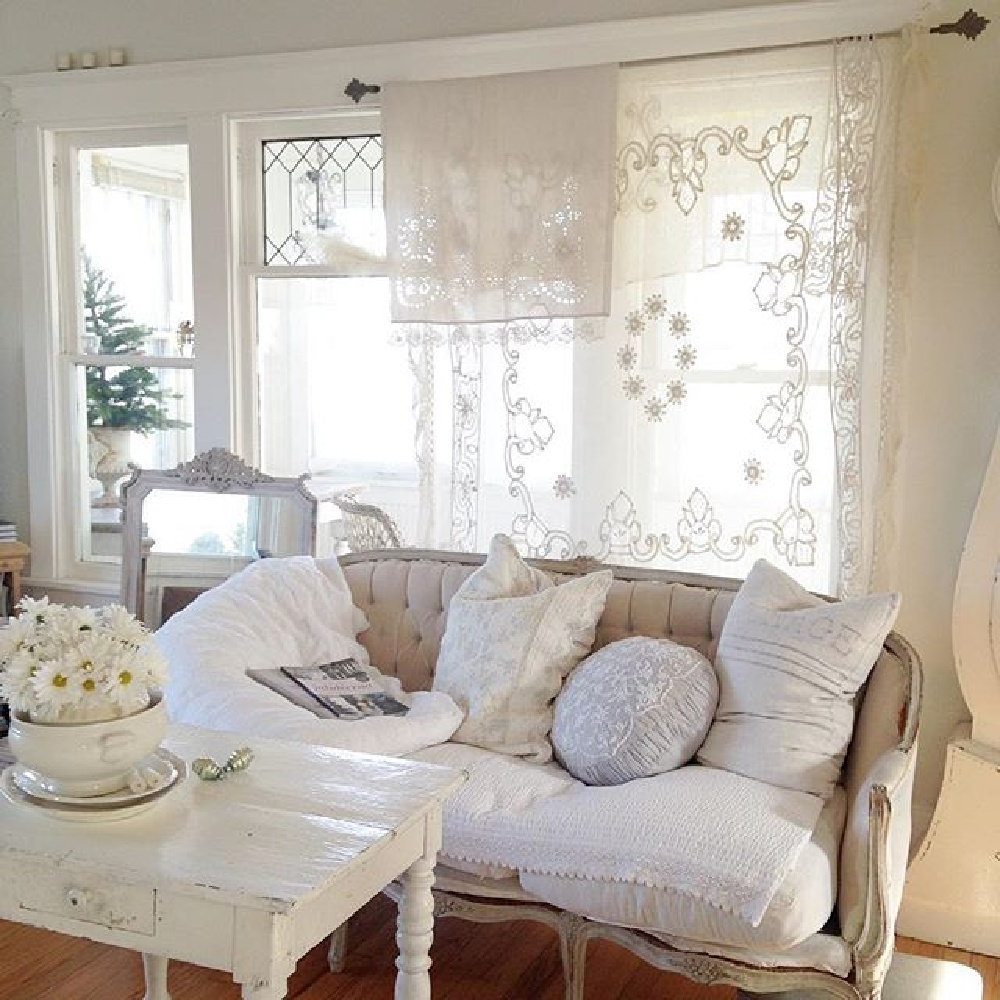 All white Swedish and French decor in a cottage with sheer lace curtains and velvet settee - My Petite Maison.