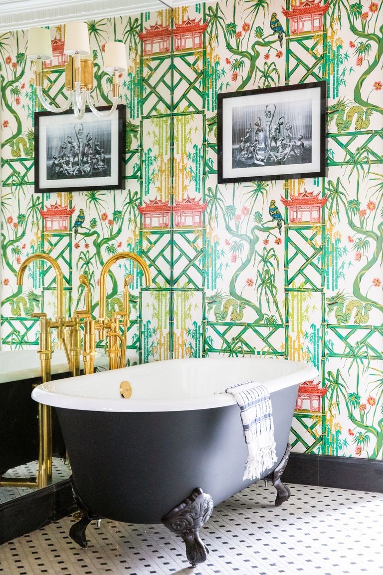 Hollywood Regency style in a bathroom with black clawfoot tub and vivid green chinoiserie wallpaper within the Prospect Hotel. Designed by Martyn Lawrence Bullard. #hollywoodregency #bathroom #interiordesign #bathroomdesign #clawfoottub #choinoiserie #wallpaper