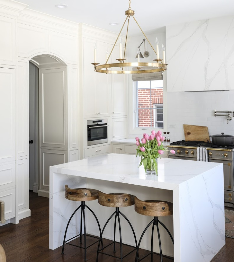 Simple yet sophisticated white elegant kitchen with brass hardware, waterfall island, and farm sink - Park and Oak. #kitchendesign #classickitchen #whitekitchen #waterfallisland ##farmsink #elegantkitchen