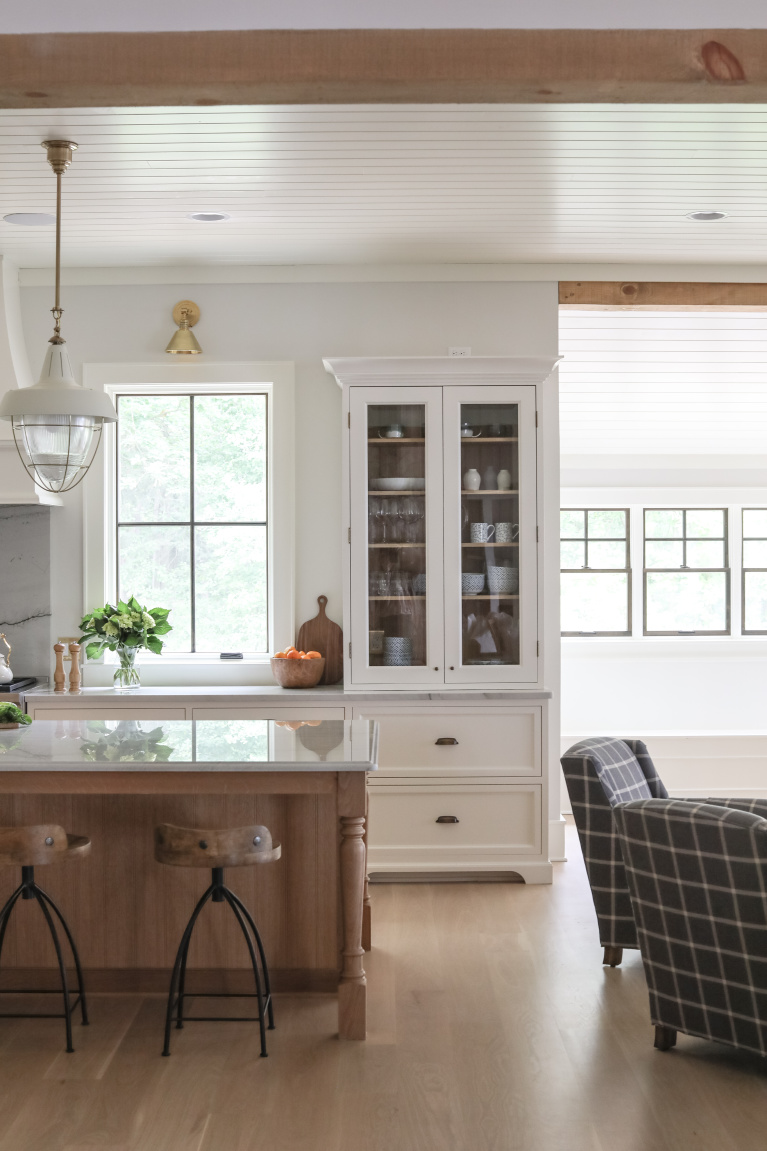 Simple yet sophisticated white coastal kitchen with contrasting wood tone island in a lake house - Park and Oak. #kitchendesign #classickitchen #whitekitchen #coastalkitchen #whiteoak #modernfarmhouse