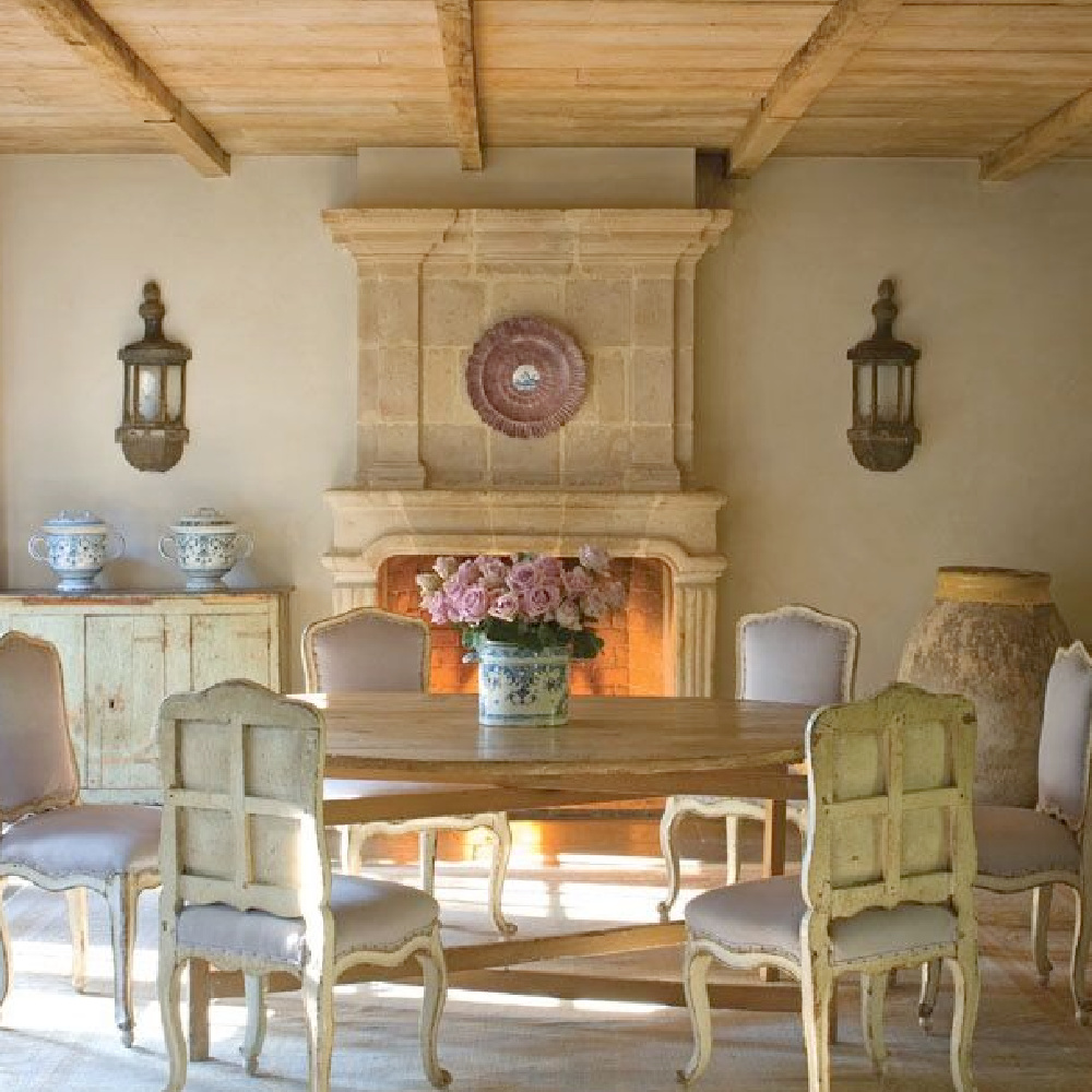 Country French dining room with rustic wood ceiling (reclaimed from Europe by Chateau Domingue), stone floors, and exquisite antique stone fireplace.