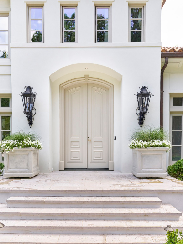 Breathtaking front door and entry to traditional style white stucco mansion in Buckhead. The 2020 Southeastern Designer Showhouse 'Villa Flora' is painted Benjamin Moore Seapearl and trim is Benjamin Moore Pashmina. #paintcolors #seapearl #benjaminmooreseapearl #pashmina #benjaminmoorepashmina #houseexteriors #housecolors