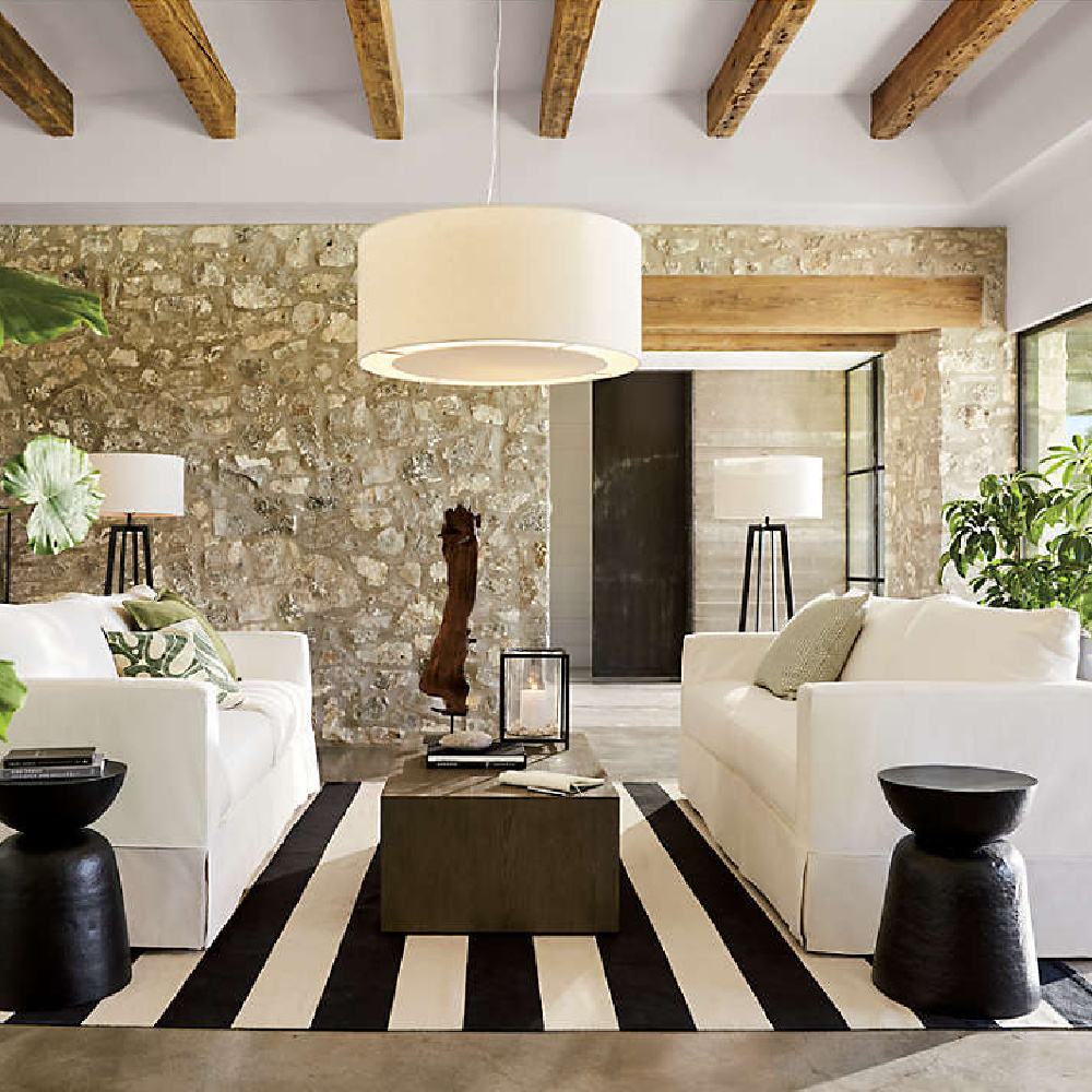 Charming rustic modern family room with beamed ceiling, stone wall, and Willow modern slipcovered sofa - Crate & Barrel. #modernrustic #familyroom #slipcoveredsofas