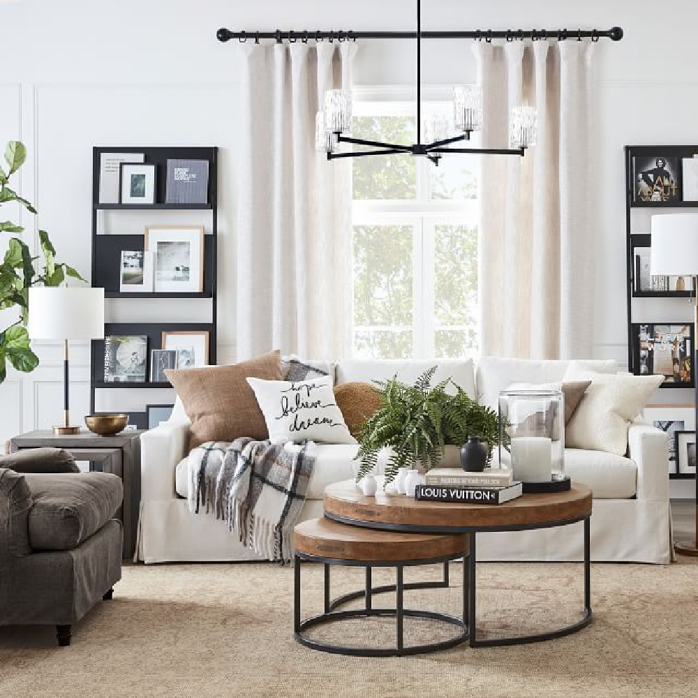 Neutral and modern rustic family room with York Slope Arm Sofa from Pottery Barn and round coffee tables. #modernrustic #familyroom #yorkslopearmsofa