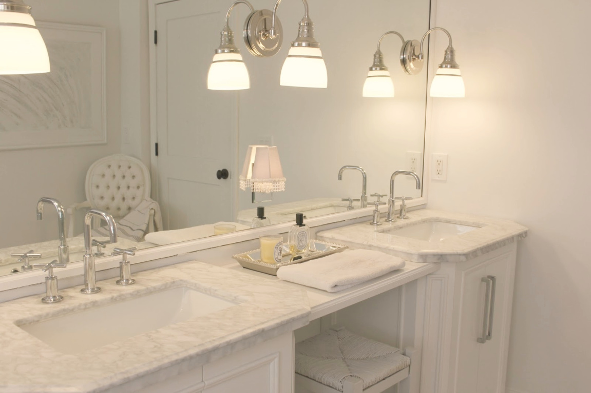 Traditional freestanding white single vanity with makeup counter in our French country bathroom with calacatta like porcelain tile. #hellolovelystudio #bathroomdesign #whitevanities #carraramarble #makeupcounter #hisandhervanities