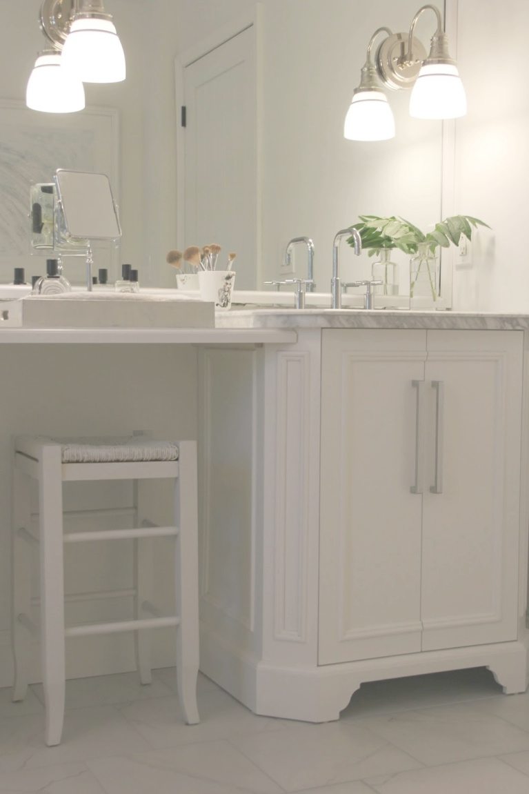 Traditional freestanding white single vanity with makeup counter in our French country bathroom with calacatta like porcelain tile. #hellolovelystudio #bathroomdesign #whitevanities #carraramarble #makeupcounter #hisandhervanities