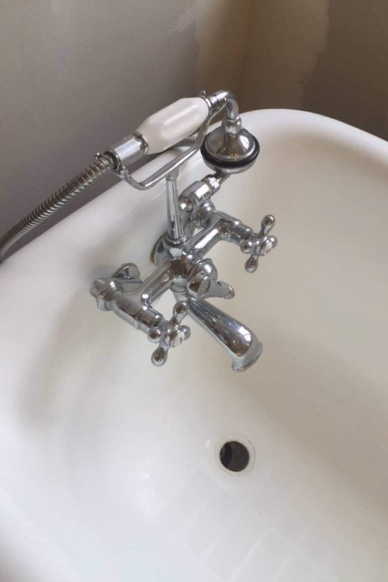 Detail of clawfoot tub bath faucet and handheld shower - Hello Lovely Studio. #clawfoottub #bathfaucet #vintagestyle