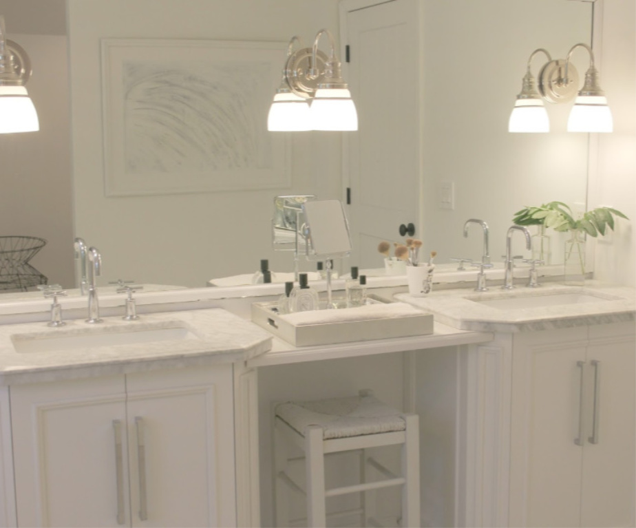 Traditional freestanding white single vanity with makeup counter in our French country bathroom with calacatta like porcelain tile. #hellolovelystudio #bathroomdesign #whitevanities #carraramarble #makeupcounter #hisandhervanities