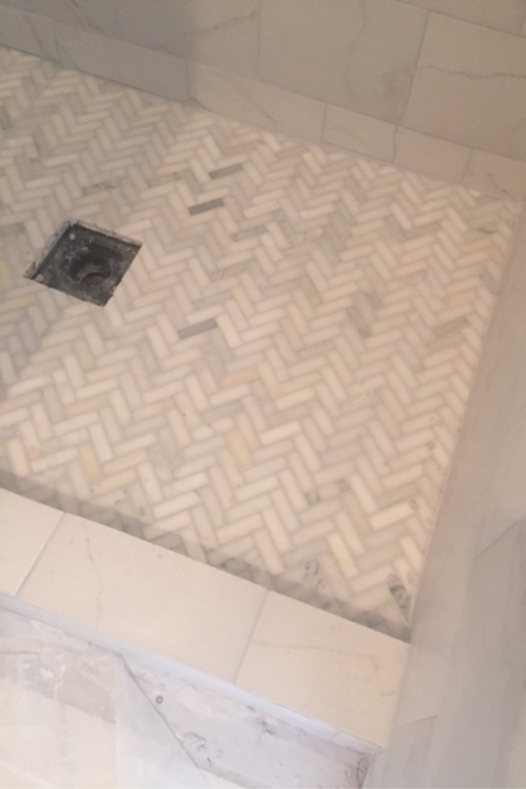 Herrinbgone marble mosaic tile on floor of our shower during renovation of master bath. #hellolovelystudio #herringbone #showertile #showerfloor #marblemosaic #floortile