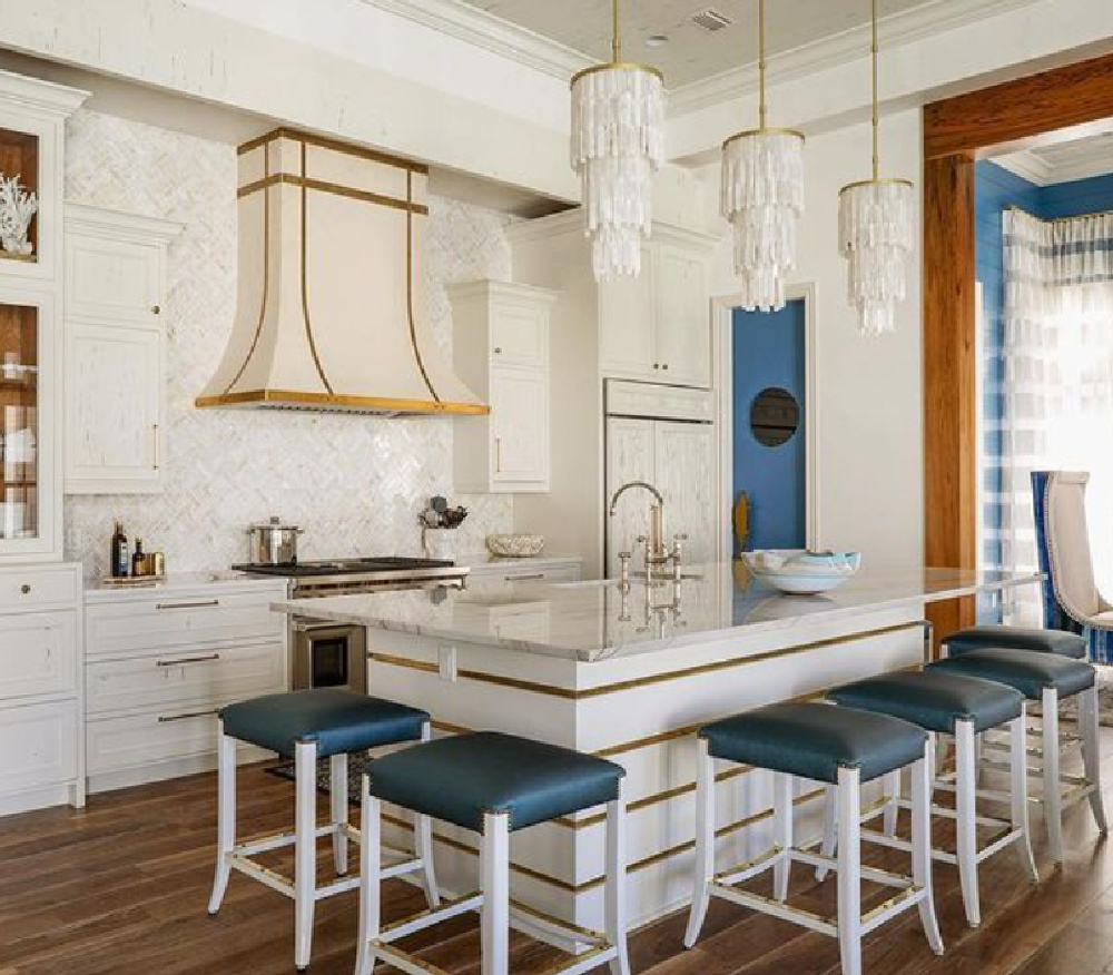 Lacquer pecky cypress cabinets, custom hood and mosaic backsplash in a chic coastal kitchen in Watercolor with architecture by Geoff Chick.