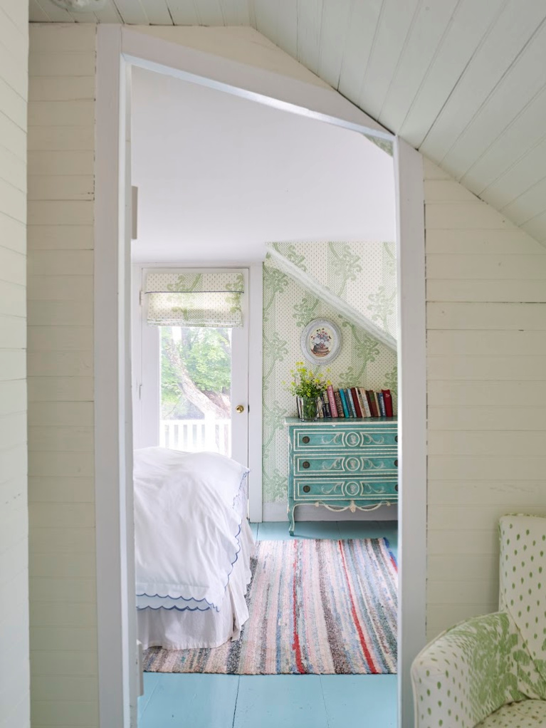 In a seaside cottage bedroom in Maine, a beautiful wallpaper (Kinnicutt by Sister Parish Design) graces the walls while turquoise paint enlivens the wood floors. #bedroomdesign #coastalstyle #vintagestyle #sisterparish #interiordesign #kinnicutt #wallpaper