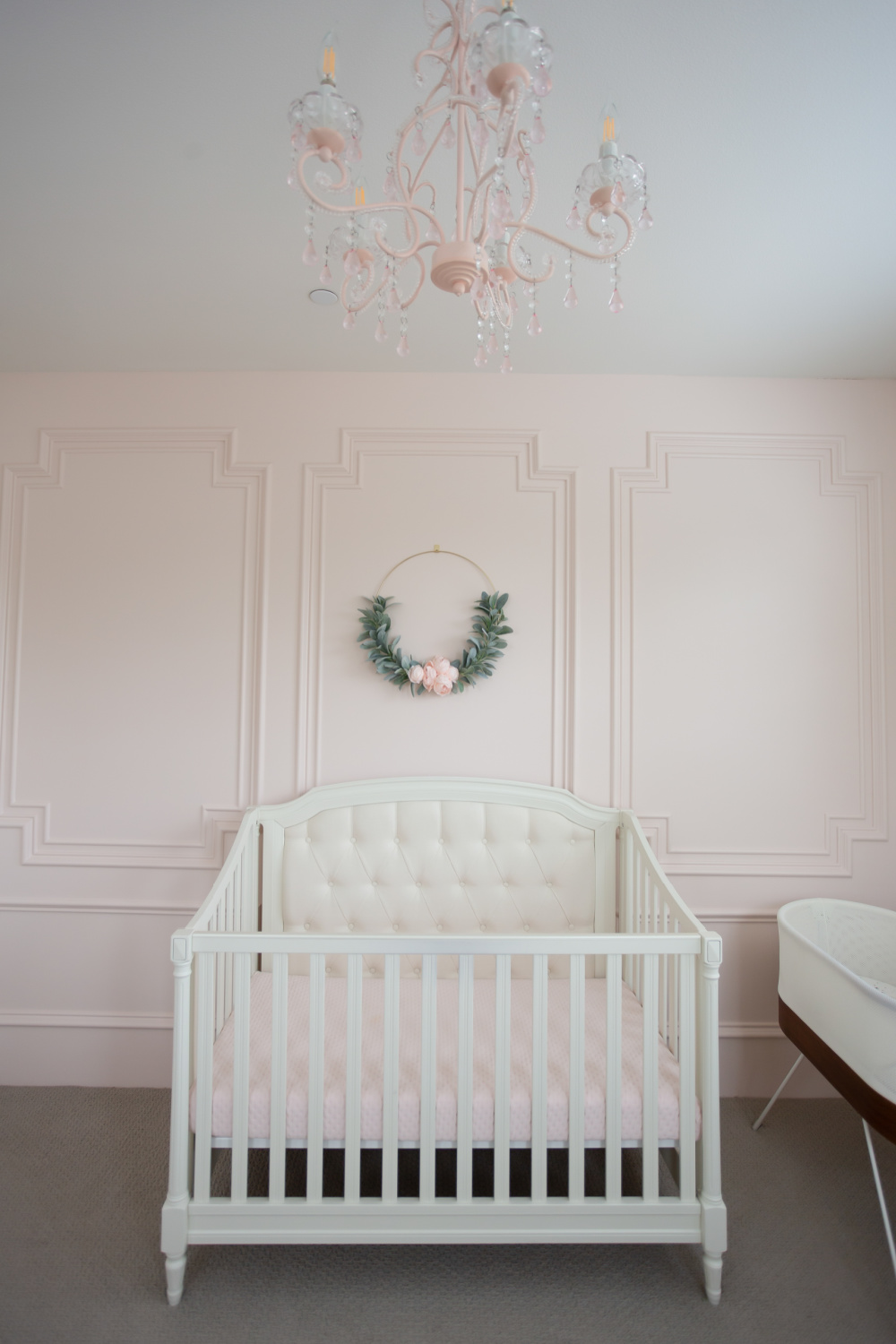 Intimate White (BM) pale blush pink painted accent wall with millwork in a beautiful nursery - StylishPetite. #intimatewhite #blushpink