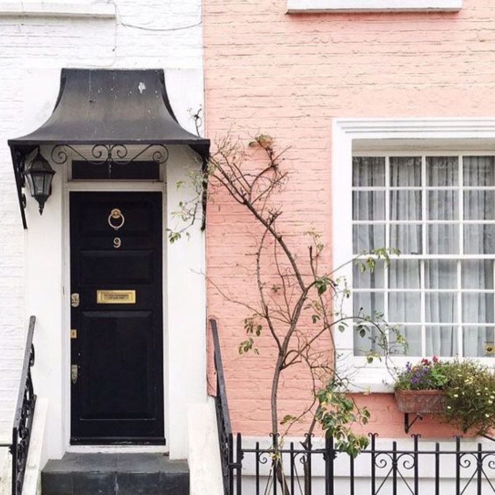 Gorgeous salmon pink painted brick on a Notting Hill home with black front door. Her Name Was Charlie.