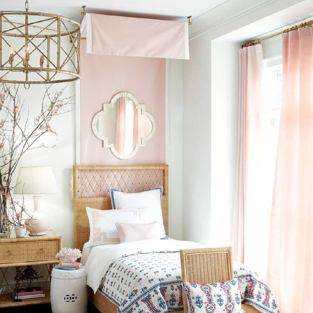 Blush pink bedroom with wicker bed designed by Suzanne Kasler for Ballard Designs.