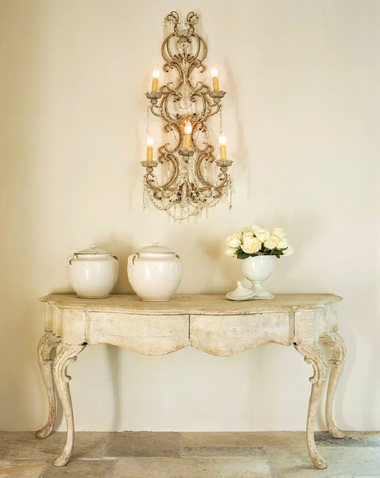 Sophisticated French inspired vignette with French pots and fanciful wall sconce in a Houston home with interiors designed by Pamela Pierce. #whitedecor #PamelaPierce #FrenchCountry #biot