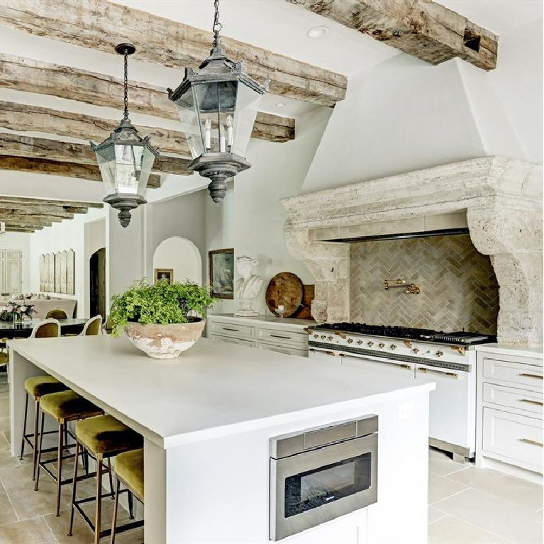 Rustic wood beams and antique street lights from Barcelona in Pale and serene French interiors in a luxurious Houston home built with authentic European materials and bespoke finishes. #timelessdesign #interiordesign #frenchcountry #europeancountry #antiques #oldworldstyle #modernfrench #frenchkitchen