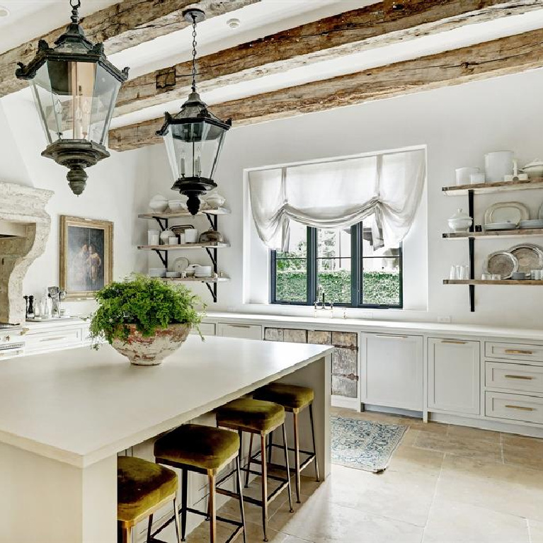 Rustic wood beams and antique street lights from Barcelona in Pale and serene French interiors in a luxurious Houston home built with authentic European materials and bespoke finishes. #timelessdesign #interiordesign #frenchcountry #europeancountry #antiques #oldworldstyle #modernfrench #frenchkitchen