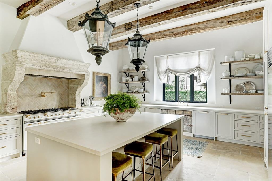 Kitchen with 16th century French mantel in Pale and serene French interiors in a luxurious Houston home built with authentic European materials and bespoke finishes. #timelessdesign #interiordesign #frenchcountry #europeancountry #antiques #oldworldstyle #modernfrench #plasterwalls