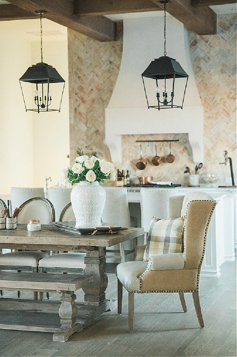 Elegant yet rustic breakfast dining area with wingback chairs in a French country home with design by Brit Jones. #diningrooms #interiordesign #frenchcountry #frenchfarmhouse