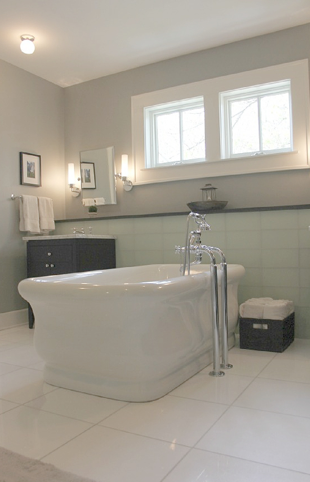 Benjamin Moore Platinum Gray wall color in bath with Waterworks tub, glass tile, and black vanities. #platinumgray #paintcolors