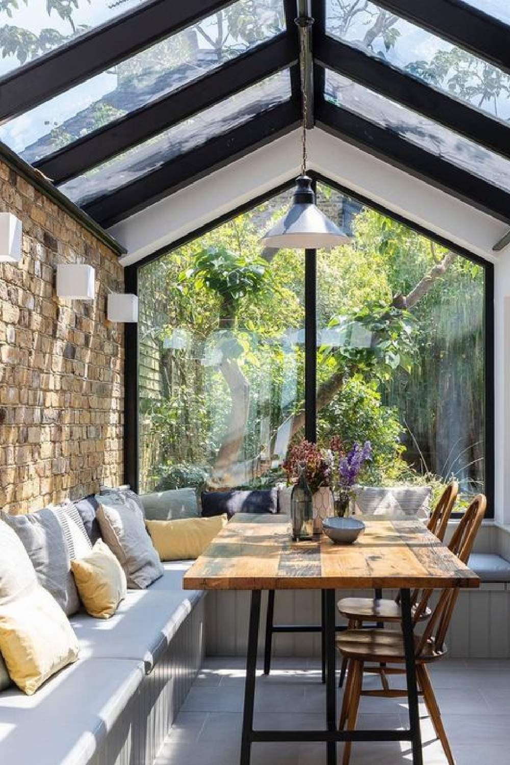 English country breakfast nook with glass roof, brick wall and built-in banquettes - Imperfect Interiors. #breakfastnook #europeancountry #interiordesign