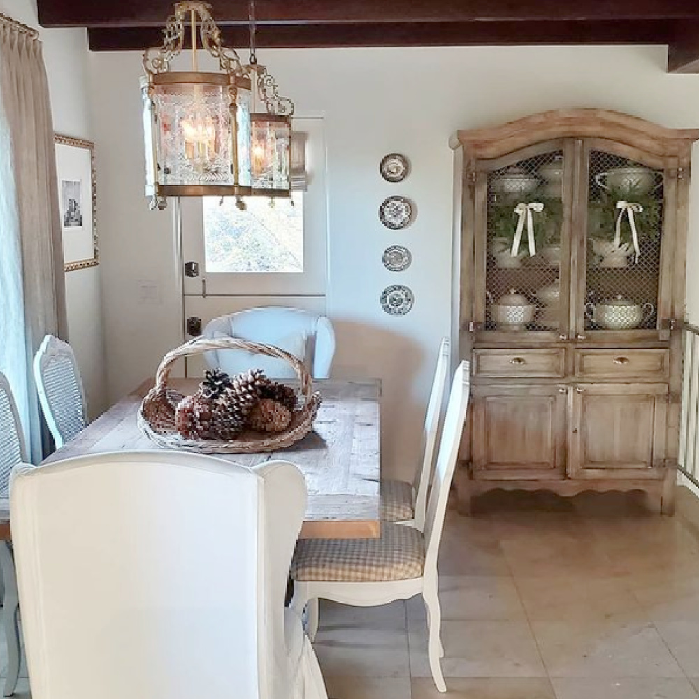 Rustic elegant French farmhouse dining room with lanterns, pale tones, plates on wall and farm table - @thefrenchnestcointeriordesign. #frenchfarmhouse #diningroom