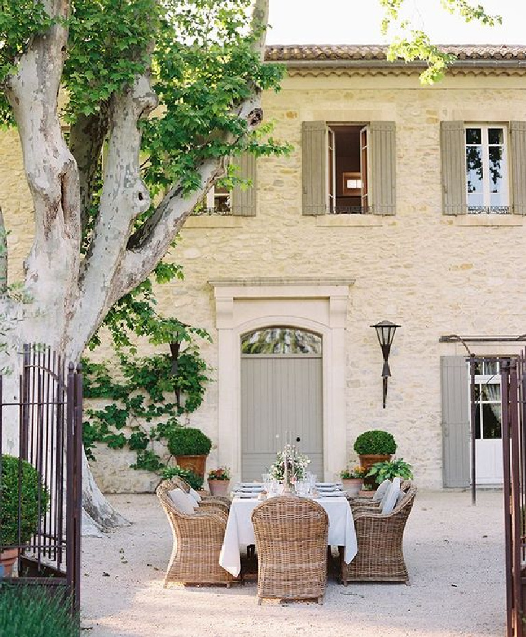 Pale stone French manor house with grey shutters and doors and dining on the gravel motor court. #frenchhome #countryhouse #southoffrance #provence #outdoordining