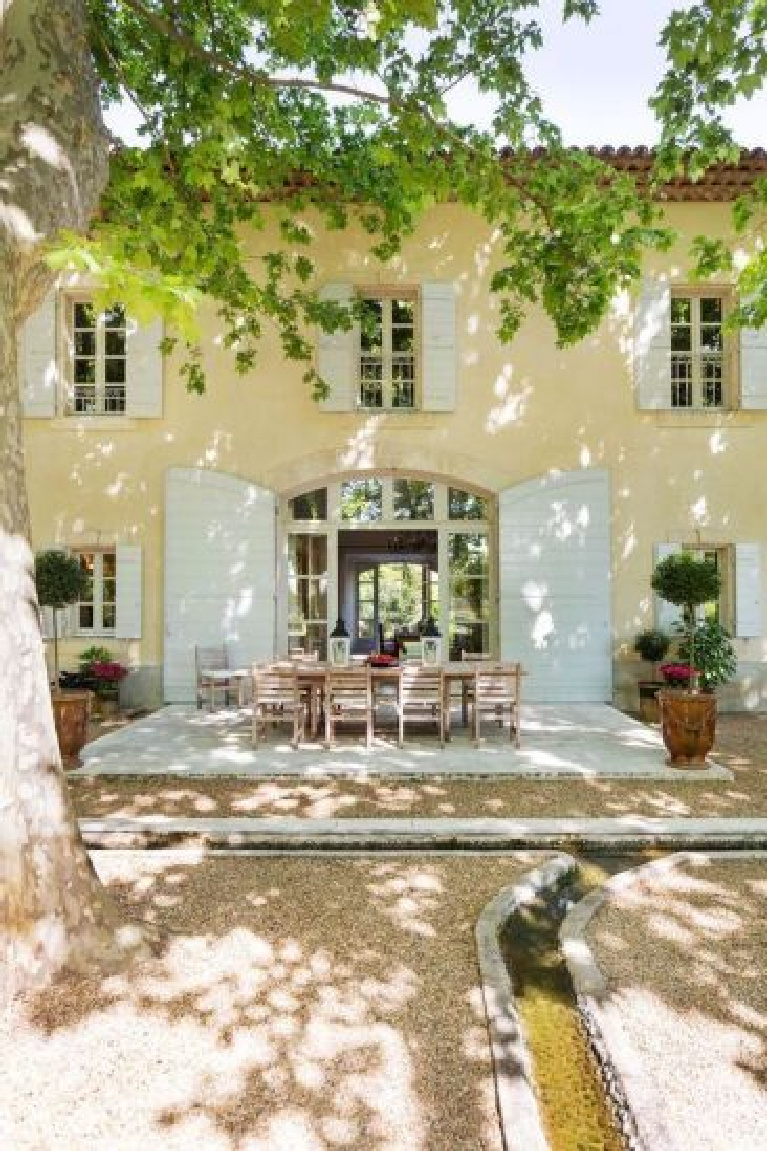 Provence style and charm reign in this picturesque outdoor dining patio with topiaries bathed in dappled light. #provence #french #chateau #outdoordining