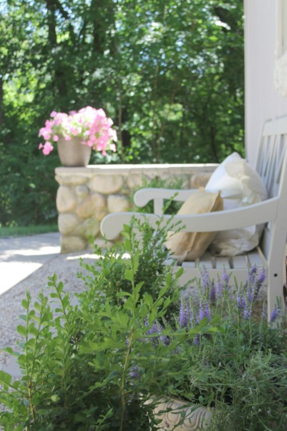 French country garden with bench and stone wall - Hello Lovely.