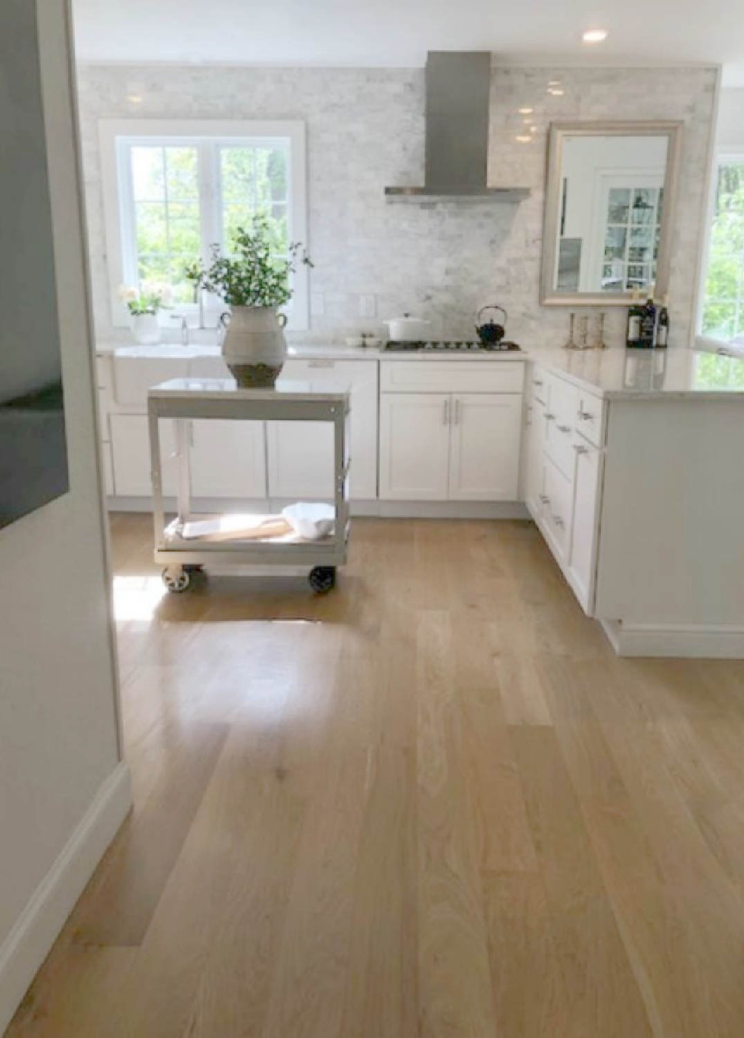 Hello Lovely's European country kitchen with white cabinets, white oak hardwoods, and industrial steel cart. #europeancountry #kitchendesign