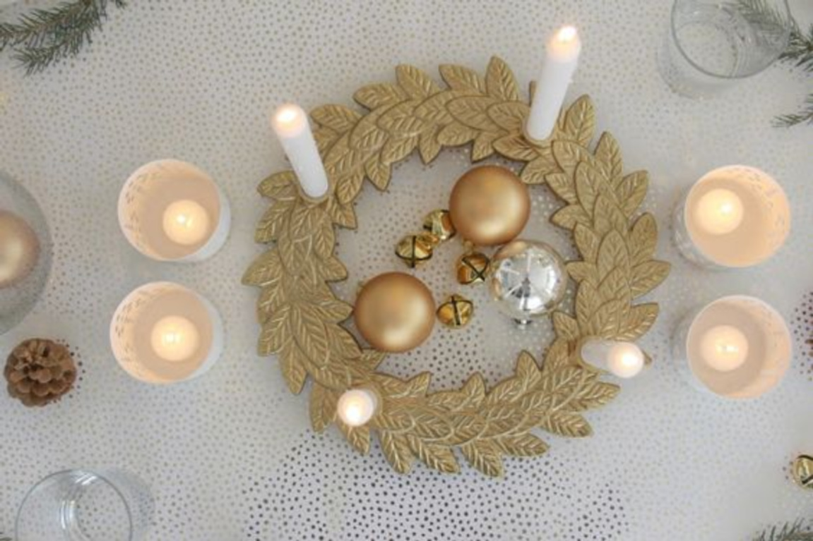 Gold and white Christmas table with advent wreath, gold ornaments, and candlelight - Hello Lovely Studio. #adventwreath #goldchristmas #goldandwhite #christmasdecor #christmastable