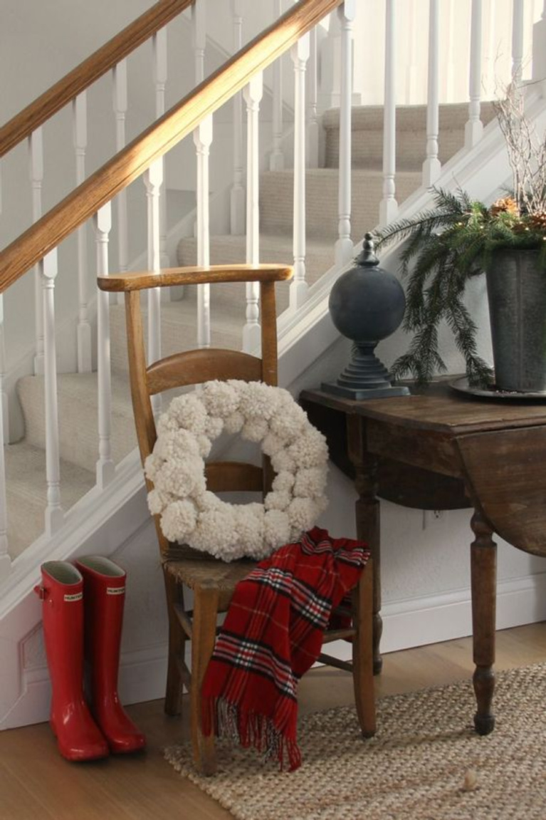 Christmas decor in Hello Lovely's entry is as simple as red boots, plaid scarf, and pom pom wreath. #hellolovelystudio #christmasdecor #holidaydecorating #simplechristmas #pompomwreath #redboots #holidayhomes and