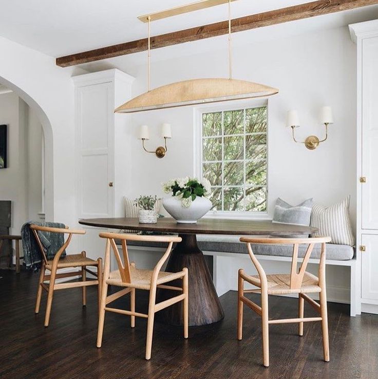 Charming breakfast nook with built in banquette, wishbone chairs, and organic rustic oval wood dining table - Jean Stoffer Design; Kenowa Builder. #breakfastnooks