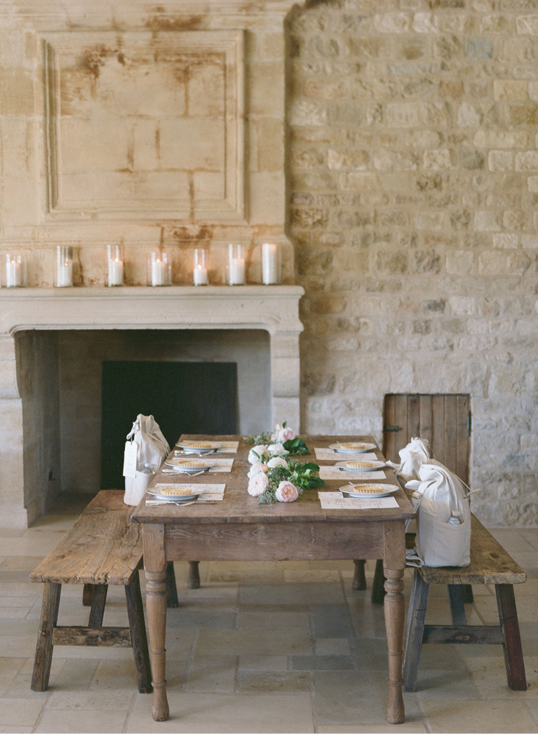 French limestone walls and antique mantel with farm table and benches at Sunstone Winery. #frenchfarmhouse #diningroom #fireplace #rusticdecor #romanticdecor