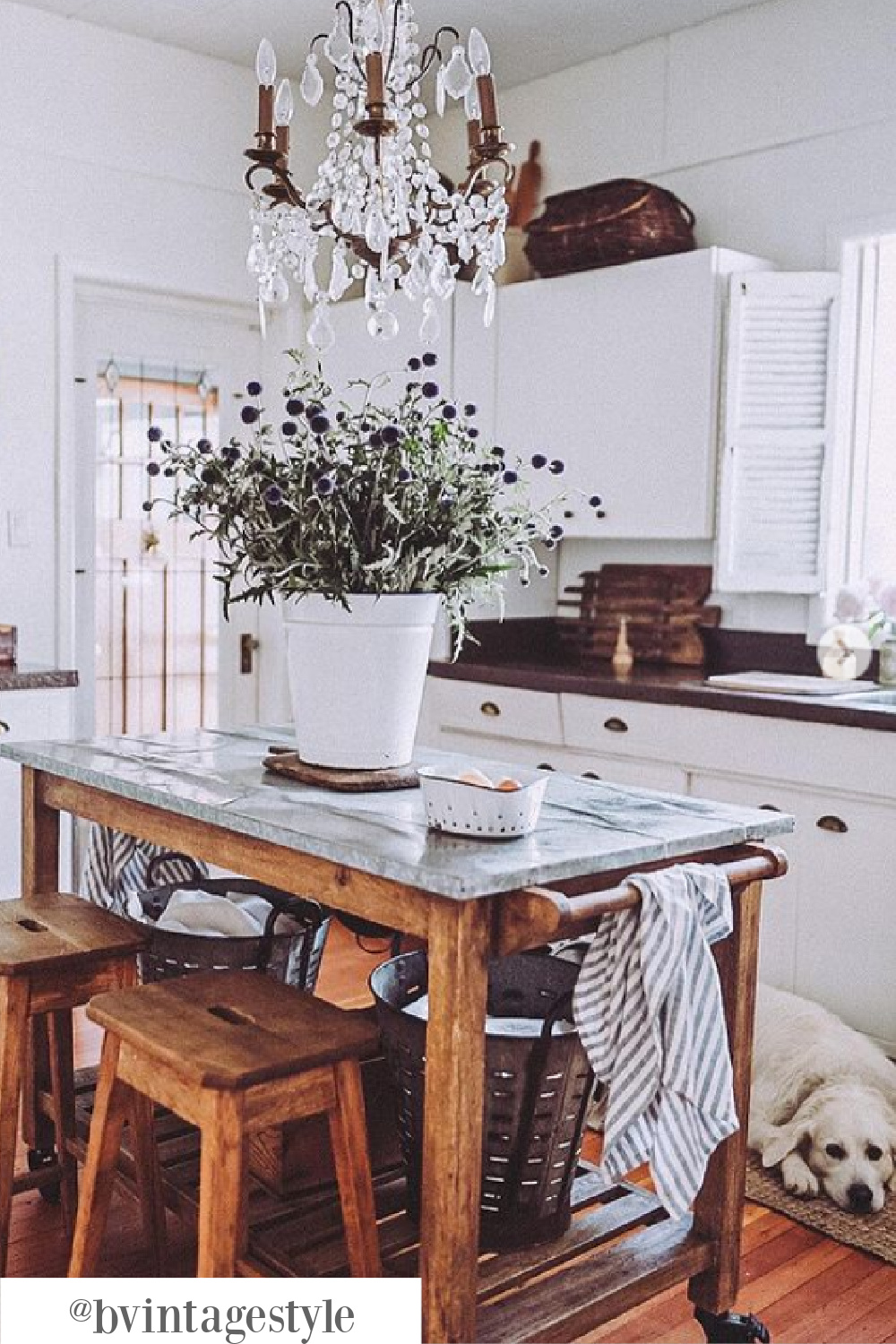 Rustic and charming white farmhouse kitchen with vintage wood work table on wheels - @bvintagestyle. #worktable #kitchencart #vintageworktable