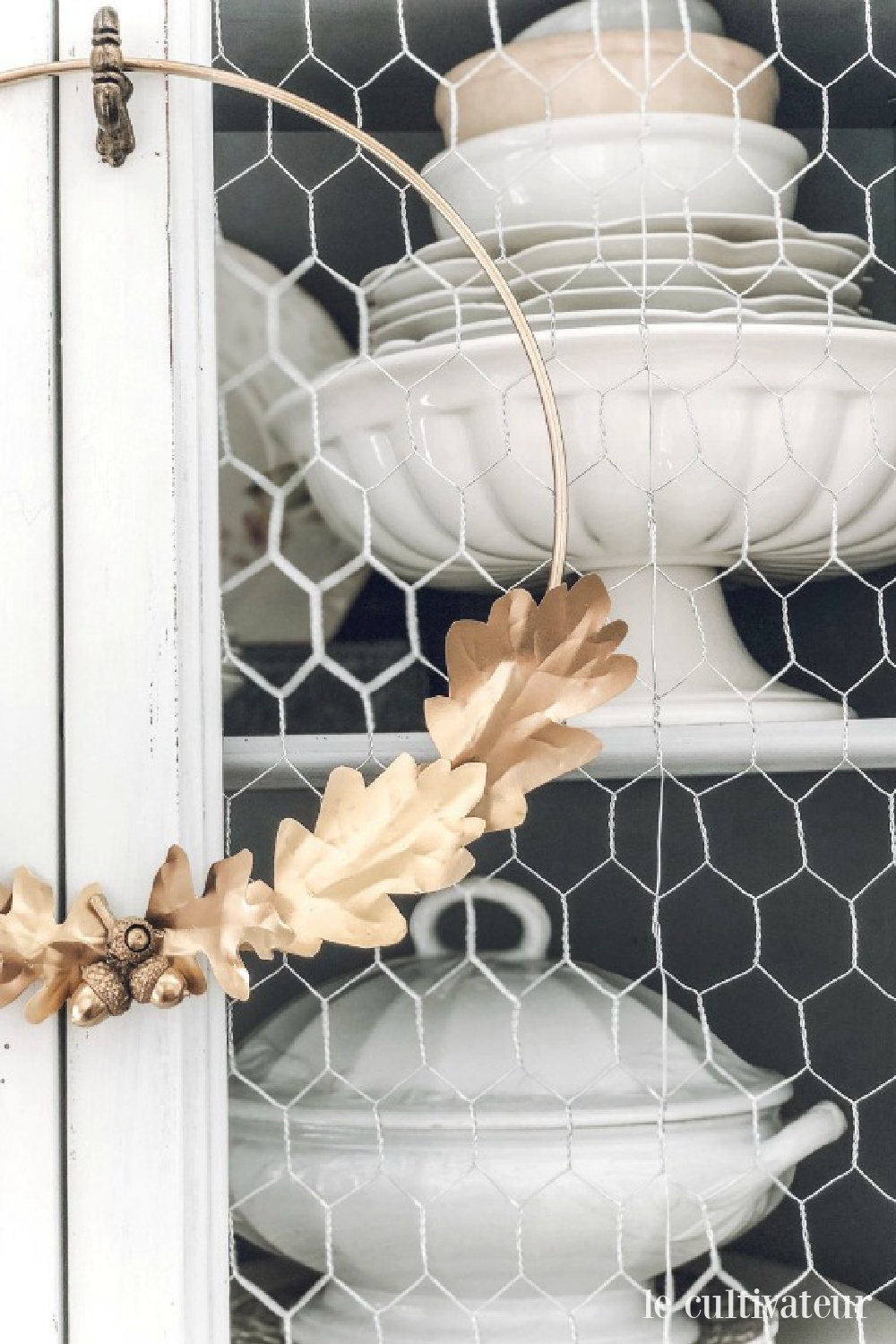 French country fall decor with white ironstone in a country vintage cabinet with chickenwire - Le Cultivateur. #falldecor #frenchcountry #ironstone #chickenwire