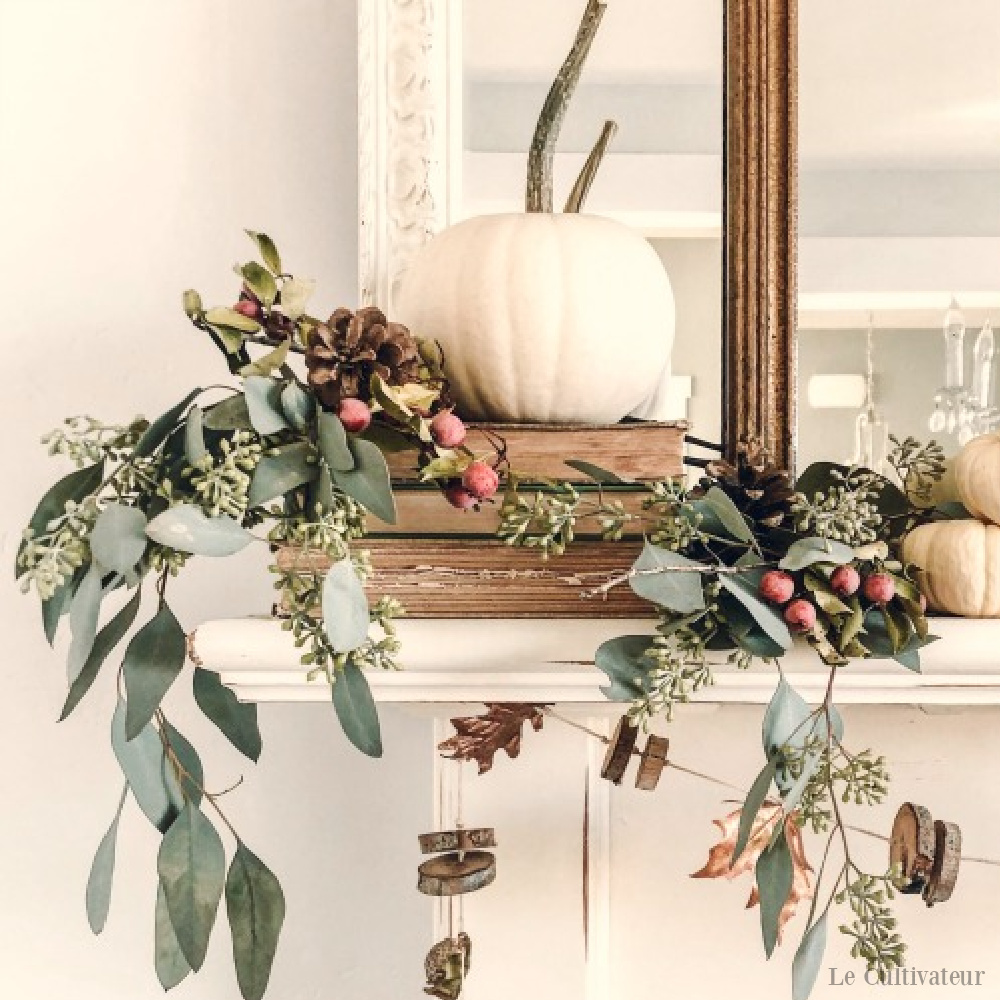 White fall French country pumpkin and acorn decor on a mantel - Le Cultivateur. #frenchcountry #falldecor #fireplacedecor