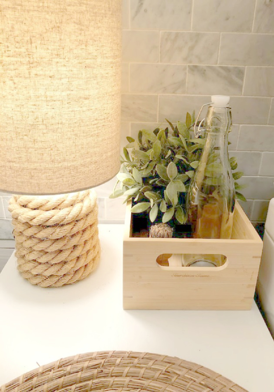 Cozy little serene things (a wee lamp, detergent in a glass bottle, polished marble backsplash tile) made a forlorn laundry pass through so much more peaceful and welcoming - Hello Lovely Studio.