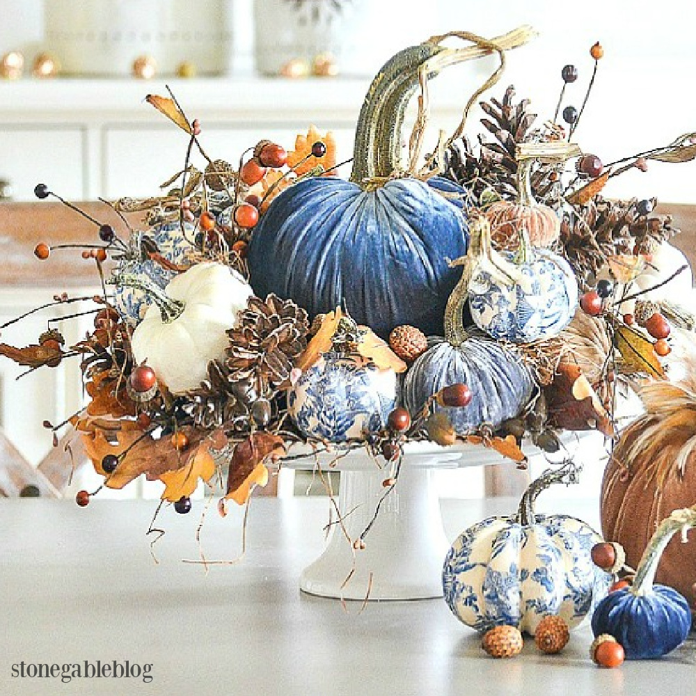 Elegant fall centerpiece with blue and white decoupaged pumpkins and royal blue velvet pumpkins - Stone Gable. Serene French Farmhouse Fall Decor Photos ahead! #centerpiece #fall #pumpkins #tablescape #velvetpumpkins #chinoiserie