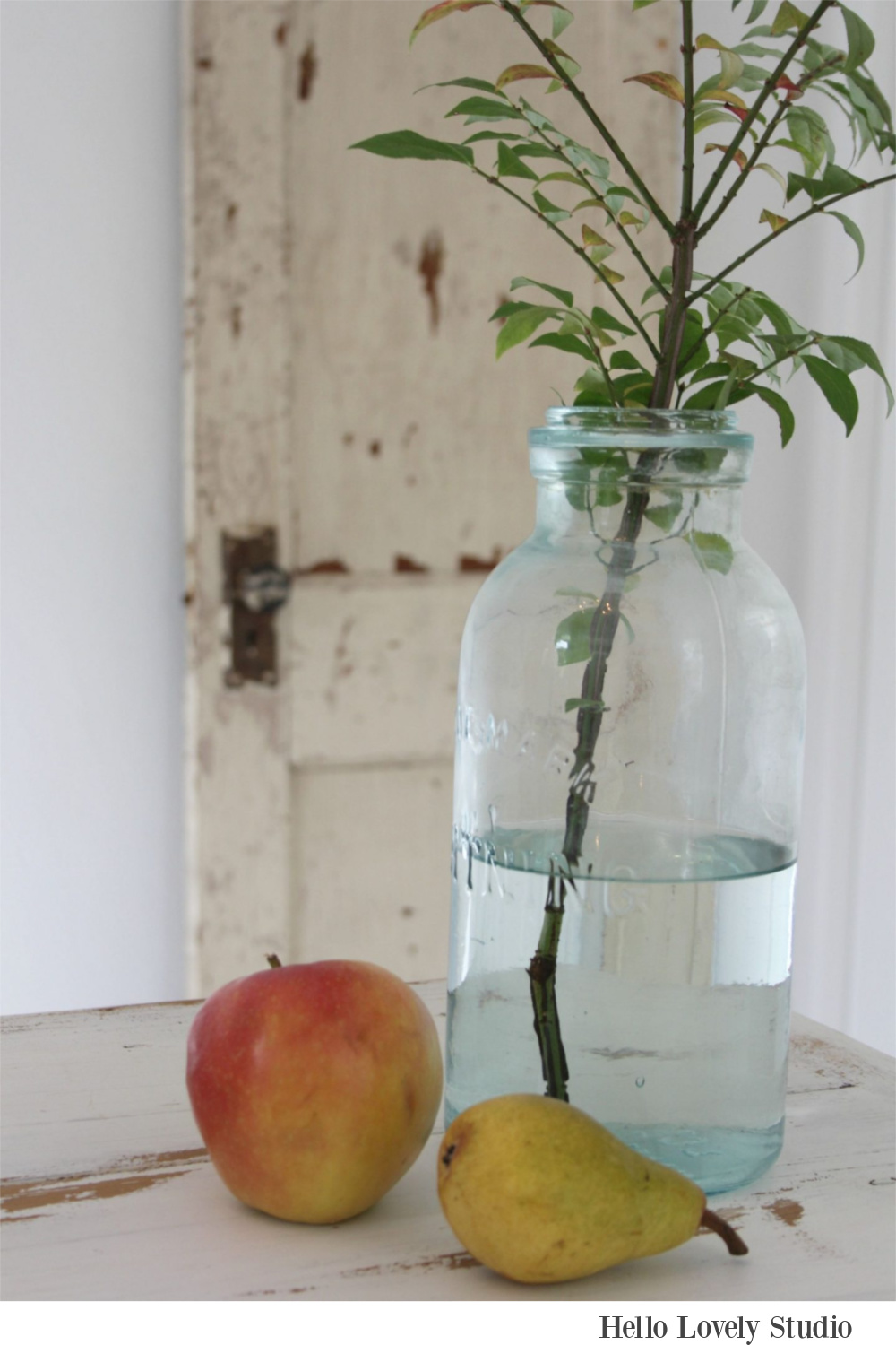 Peaceful, soft farmhouse still life with green mason jar, fruit, and a peely painted door - Hello Lovely Studio.