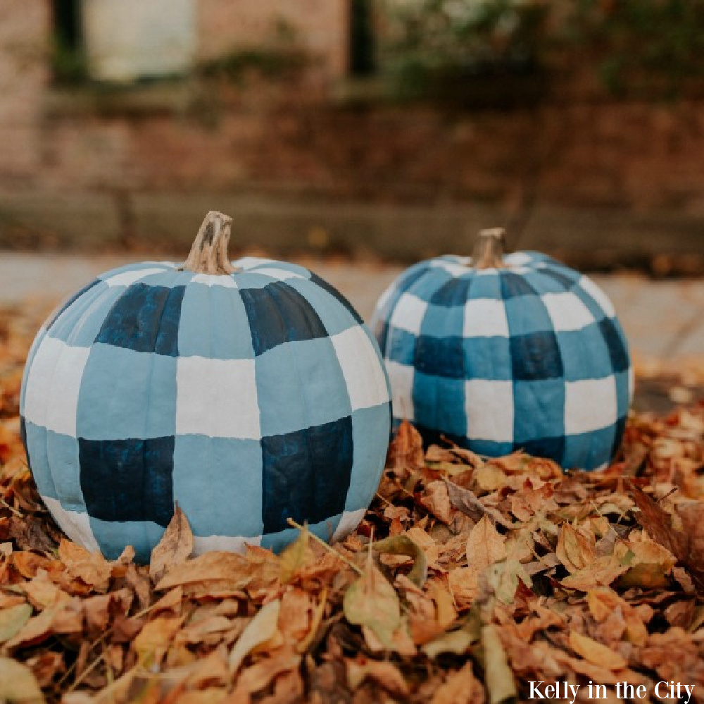 Blue plaid painted pumpkins in orange fallen leaves - Kelly in the City. Serene French Farmhouse Fall Decor Photos ahead! #pumpkins #DIY #plaid #buffalochecks #farmhousedecor