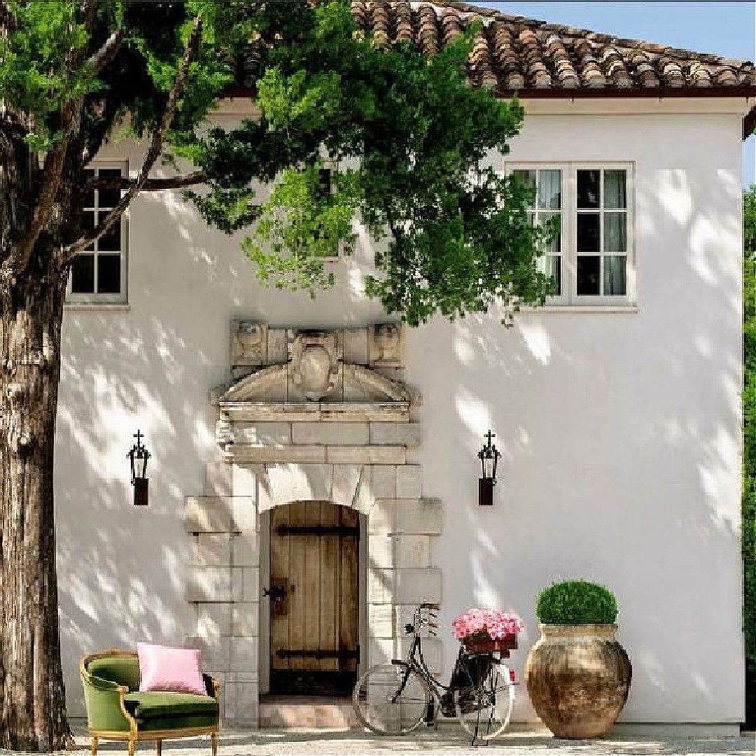 Fairytale French farmhouse style stucco house exterior with magnificent antique limestone around arched front door - Reagan Andre Architect - appeared in preview issue of MILIEU magazine, 2013. #frenchfarmhouse #pamelapierce #annetteschatte