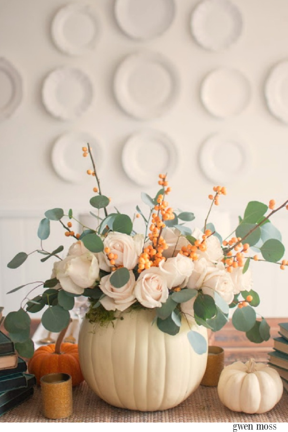 Gorgeous and simple fall centerpiece with white pumpkins, roses, bittersweet and eucalyptus - Gwen Moss. #falltable #pumpkincenterpiece #thanksgiving #tabledecor